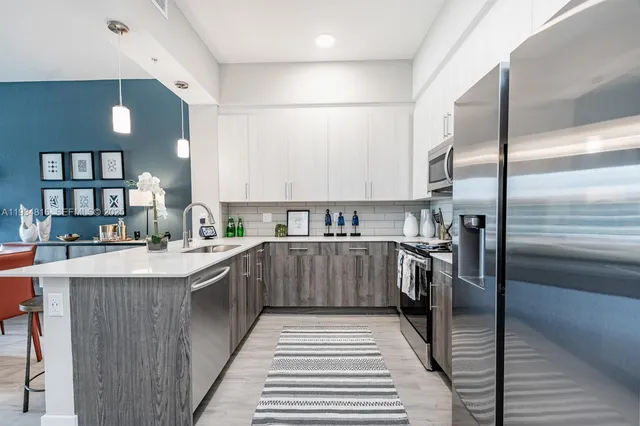 a kitchen with stainless steel appliances a sink and a refrigerator