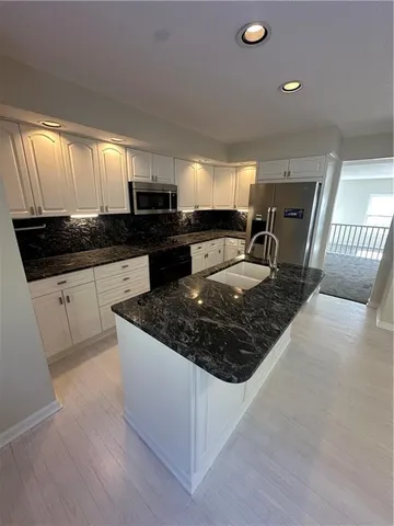 a kitchen with stainless steel appliances granite countertop a sink stove and cabinets