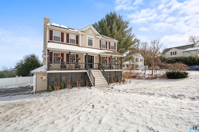 a view of a house with a yard covered in snow