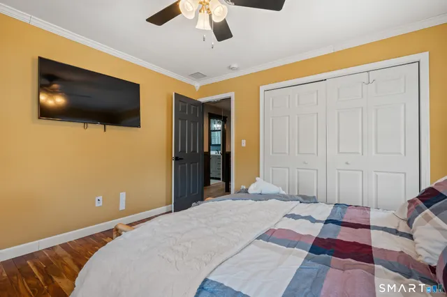 a bedroom with a bed and wooden floor