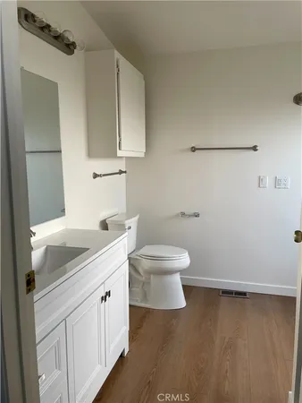 a bathroom with a granite countertop sink a toilet and a mirror