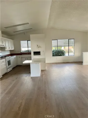 a kitchen with stainless steel appliances kitchen island wooden floors and white cabinets