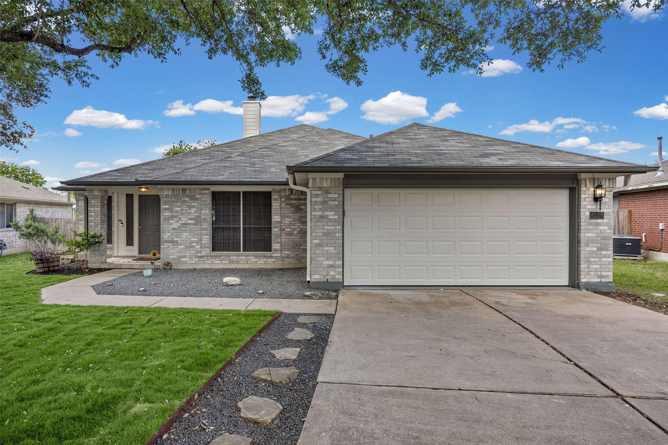 1524 Lochaline Loop Pflugerville, TX 78660 - Photo 4 of 22 A well-maintained facade with a gray brick exterior and an inviting entryway.