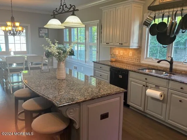 a kitchen with kitchen island granite countertop a sink a stove and a wooden cabinets