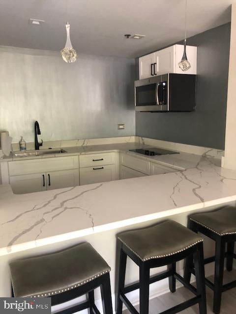 1600 Hagys Ford Road, Unit 5M Penn Valley, PA 19072 - Photo 15 of 18 a kitchen with a table chairs microwave and cabinets