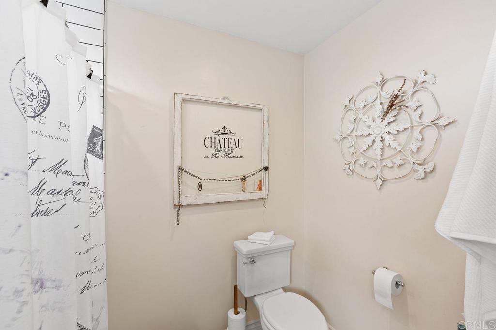 3433 Royal Road Vista, CA 92084 - Photo 23 of 45 a bathroom with a toilet and a shower curtain