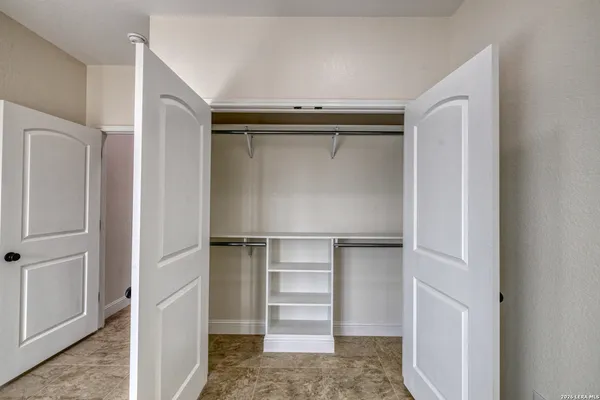 a view of walk in closet with empty racks