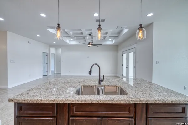 a kitchen with kitchen island granite countertop a sink cabinets and stainless steel appliances