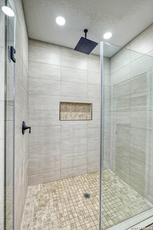 a bathroom with a granite countertop sink a mirror and shower