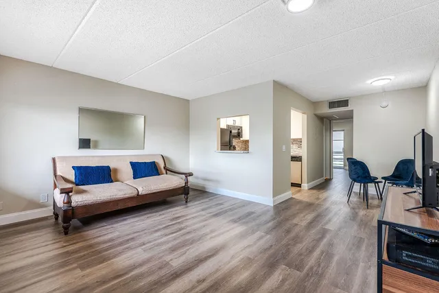 a living room with furniture and a wooden floor