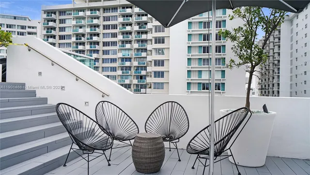 a balcony with table and chairs