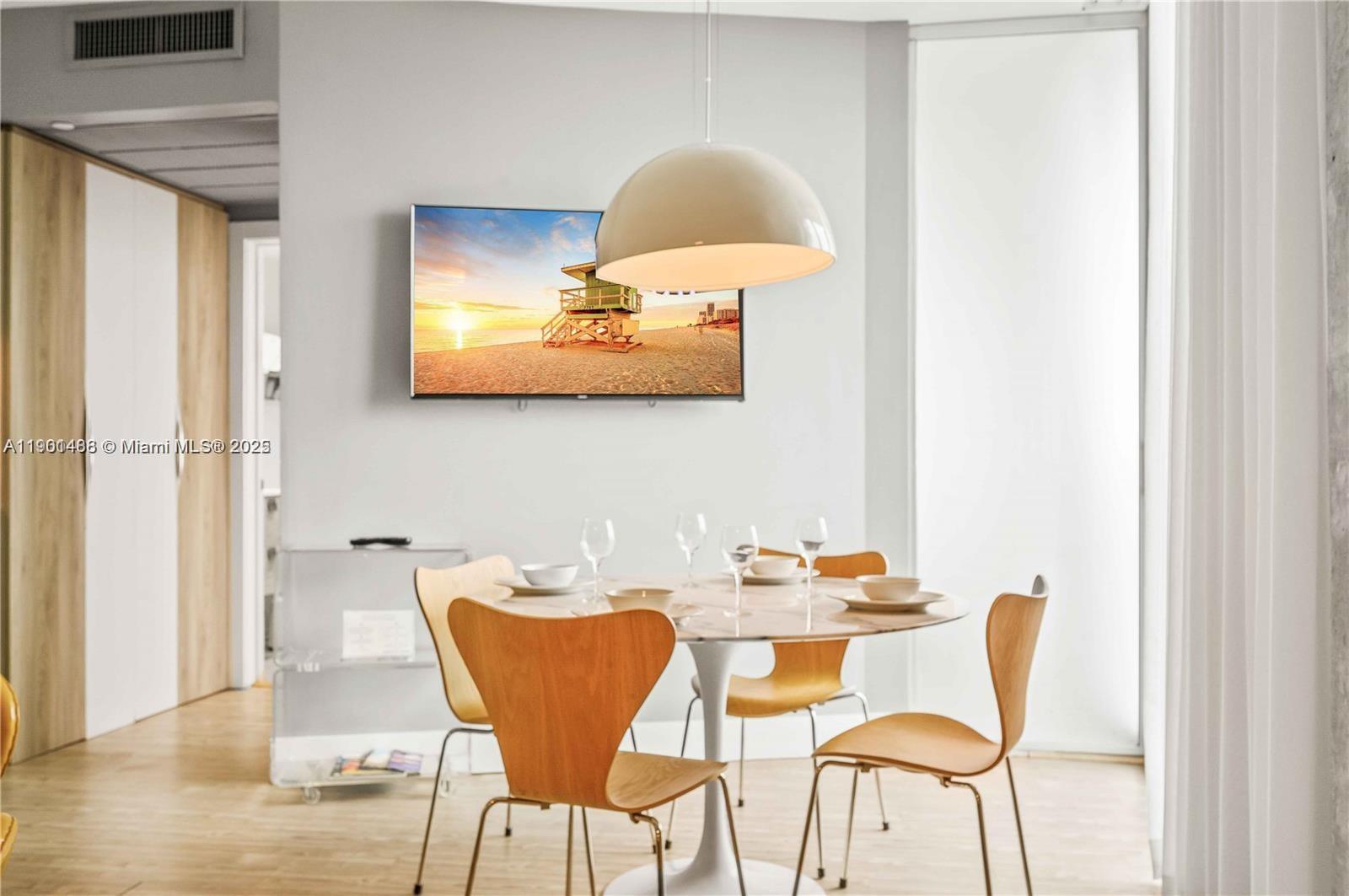 1215 West Avenue, Unit 605 Miami Beach, FL 33139 - Photo 5 of 19 a dining room with furniture and wooden floor