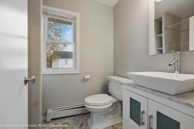 a bathroom with a granite countertop toilet sink and mirror