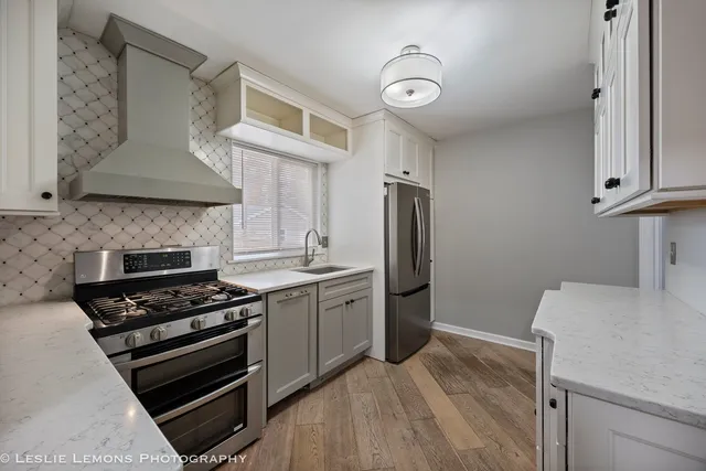 a kitchen with stainless steel appliances a stove a sink and a refrigerator