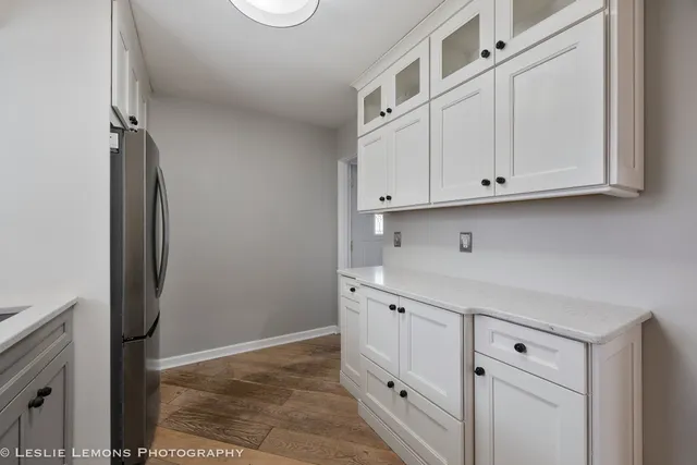 a view of an empty room and closet with wooden floor