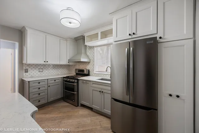 a kitchen with white cabinets and stainless steel appliances