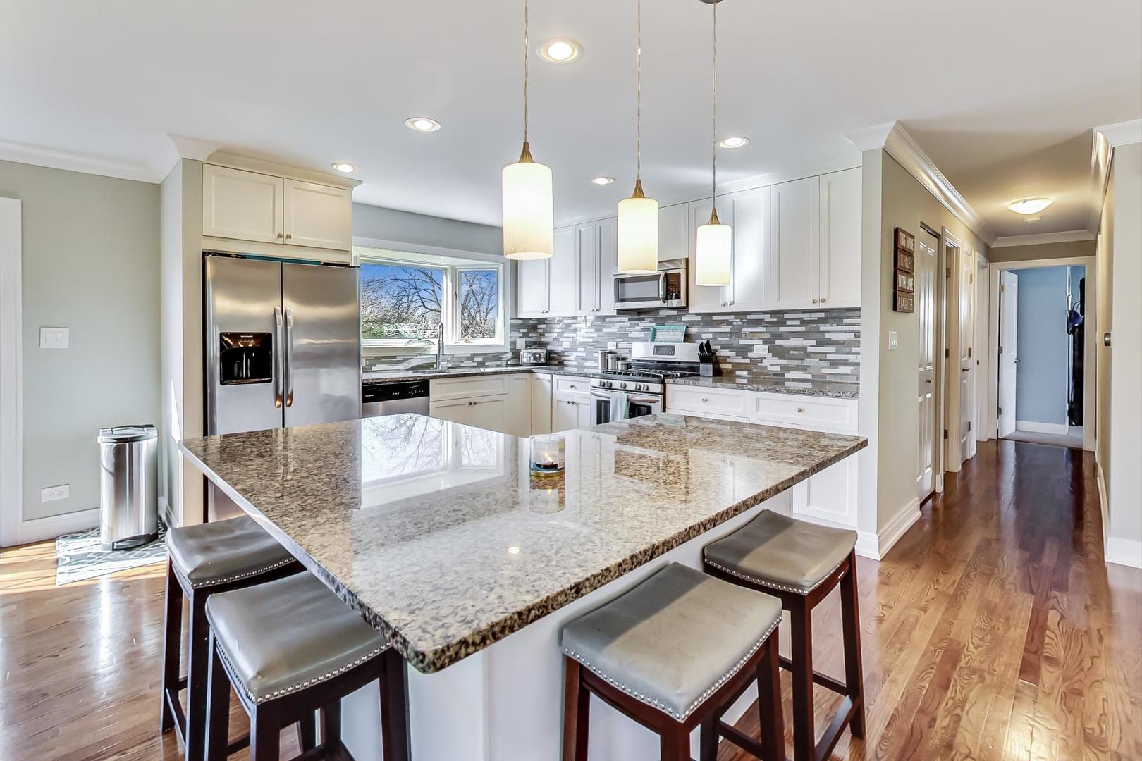 34 Timber Hill Road Buffalo Grove, IL 60089 - Photo 8 of 37 a kitchen with stainless steel appliances granite countertop a kitchen island a stove a table and chairs