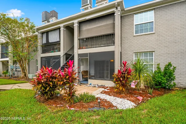a view of a house with a yard and potted plants