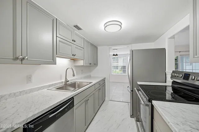 a kitchen with granite countertop stainless steel appliances and sink