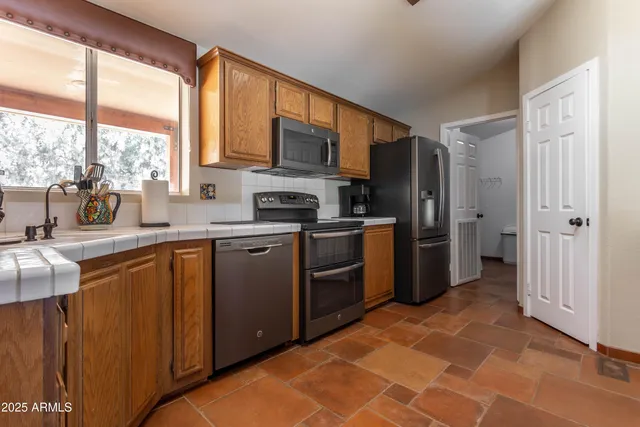 a living room with furniture a flat screen tv and a large window