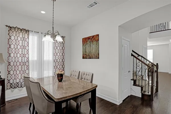 a view of a dining room with furniture wooden floor and chandelier