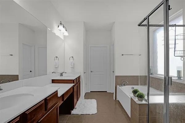 a spacious bathroom with a granite countertop sink a shower and a mirror