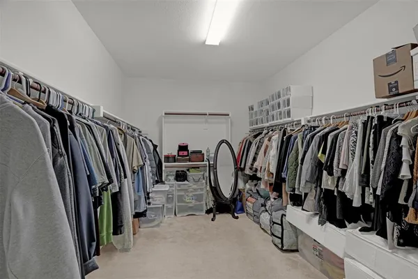 a view of walk in closet with clothes and shoes