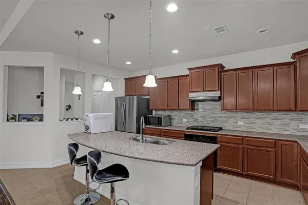 a kitchen with kitchen island granite countertop a sink and cabinets
