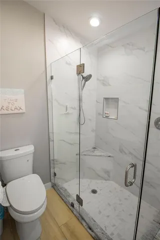 a bathroom with a toilet and a shower