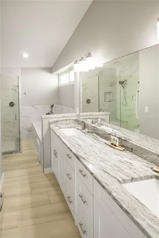 a spacious bathroom with a granite countertop double vanity sink mirror and