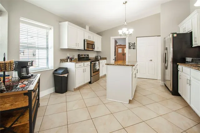 a kitchen with stainless steel appliances granite countertop a refrigerator stove top oven and sink