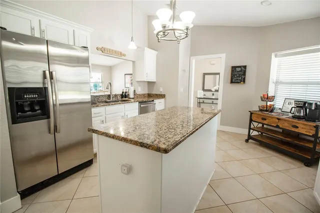 a kitchen with stainless steel appliances granite countertop a refrigerator a sink and a stove