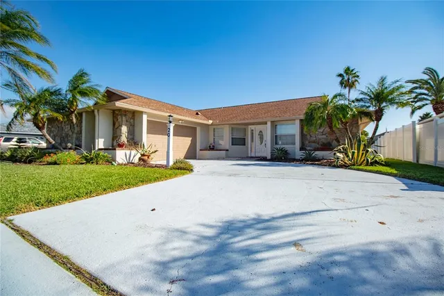a front view of a house with a yard and potted plants
