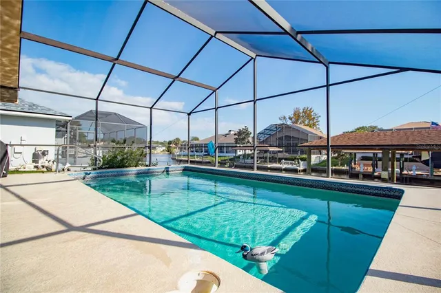 a view of a swimming pool with a patio and a yard