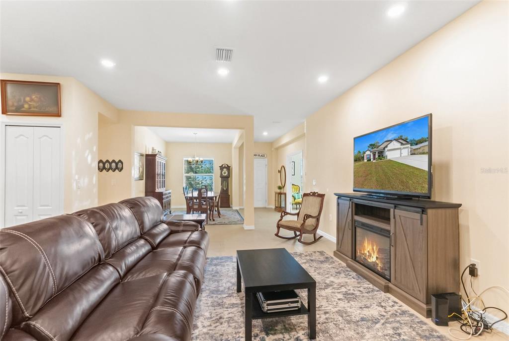 6283 Grapewood Road Spring Hill, FL 34609 - Photo 14 of 41 a living room with furniture flat screen tv and a fireplace