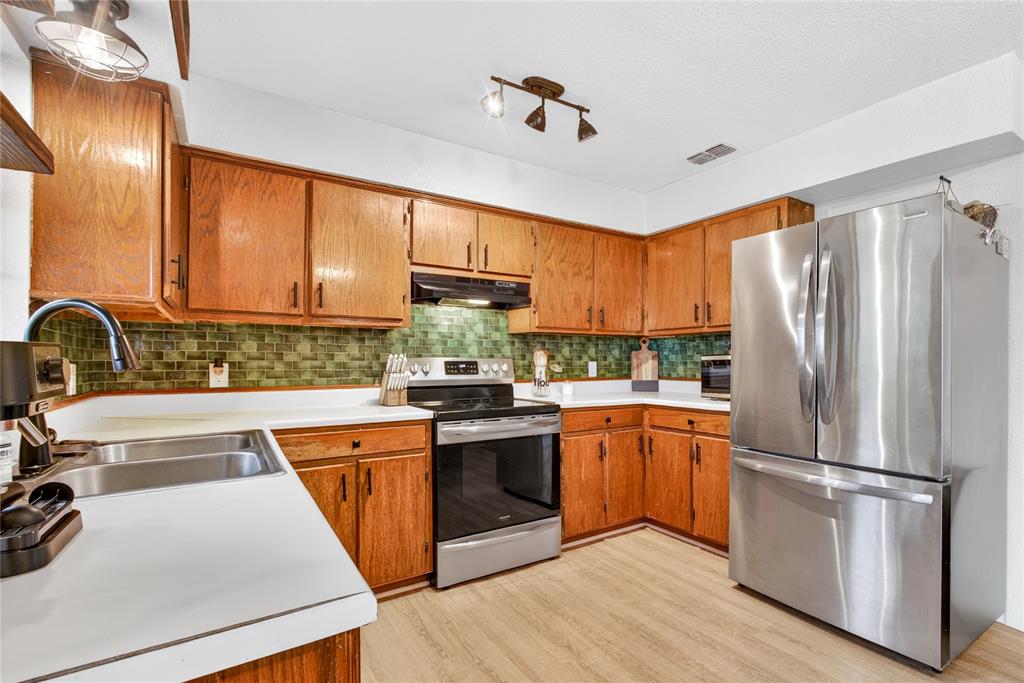 703 College Street Celeste, TX 75423 - Photo 11 of 29 a kitchen with stainless steel appliances granite countertop a refrigerator sink and cabinets