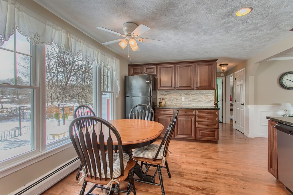 32 Shawnee Road Pepperell, MA 01463 - Photo 5 of 27 a kitchen with stainless steel appliances granite countertop a stove a refrigerator a sink a dining table and chairs with wooden floor