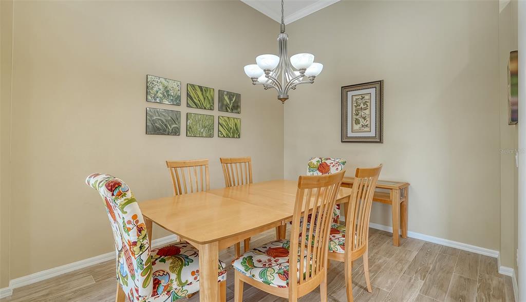 7717 US Open Loop Lakewood Ranch, FL 34202 - Photo 18 of 95 a view of a dining room with furniture and chandelier