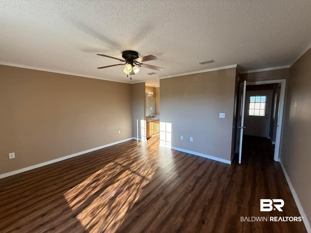 8912 Sherman Road Foley, AL 36535 - Photo 29 of 35 Interior space featuring dark wood-style floors, visible vents, baseboards, and a ceiling fan