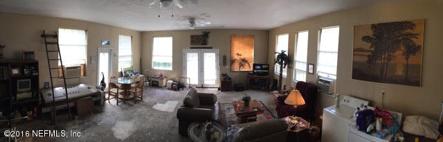 10235 Shark Road West Jacksonville, FL 32226 - Photo 19 of 40 a living room with furniture and a floor to ceiling window