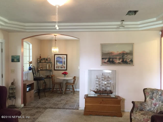 10235 Shark Road West Jacksonville, FL 32226 - Photo 9 of 40 a living room with furniture and a chandelier
