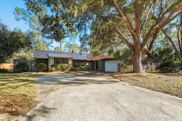 a view of a house with a yard and large tree