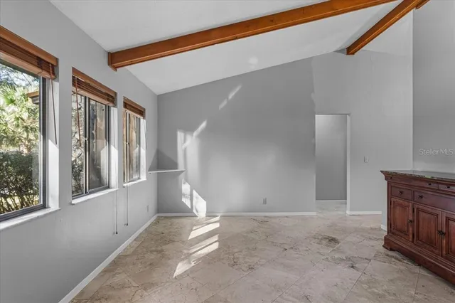 an empty room with windows and a chandelier fan