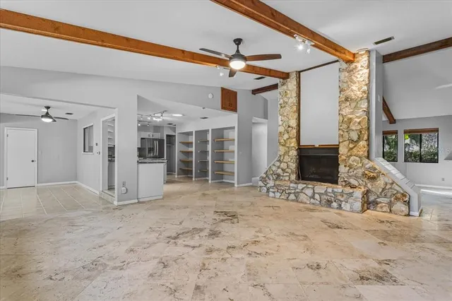 a view of empty room with wooden floor and fireplace