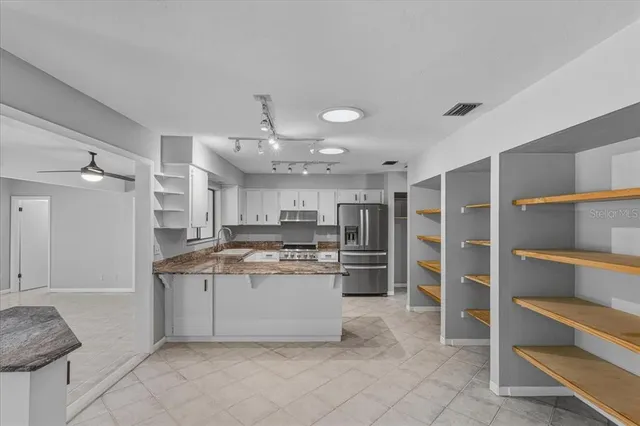 a kitchen with kitchen island a sink stainless steel appliances and cabinets