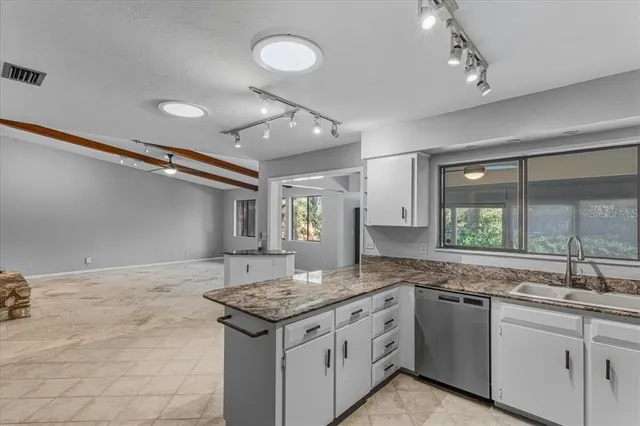 a kitchen with granite countertop a sink and a stove