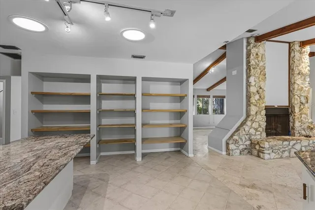 a view of an empty room with a fireplace and a window
