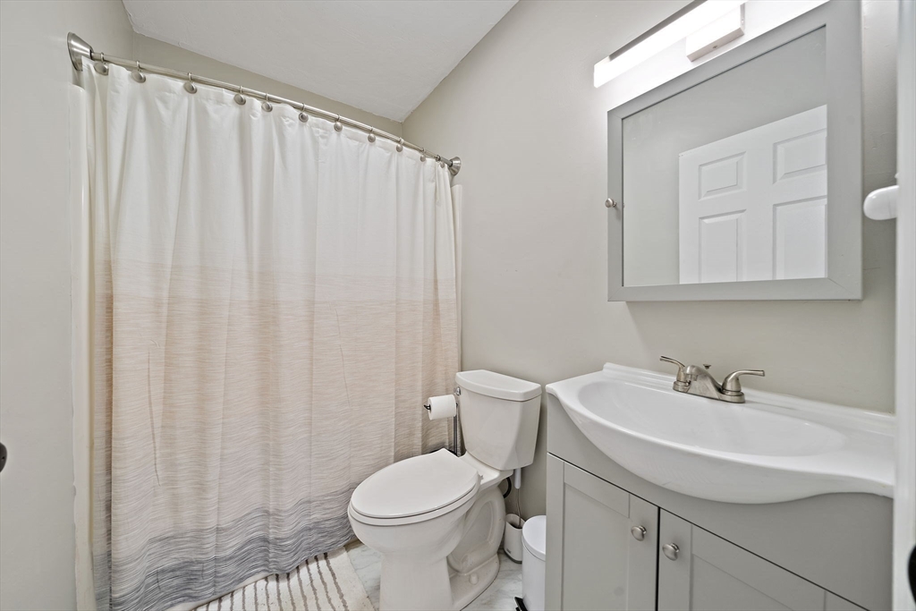22 Union Square, Unit 22 Randolph, MA 02368 - Photo 23 of 28 a bathroom with a sink a toilet and shower curtain