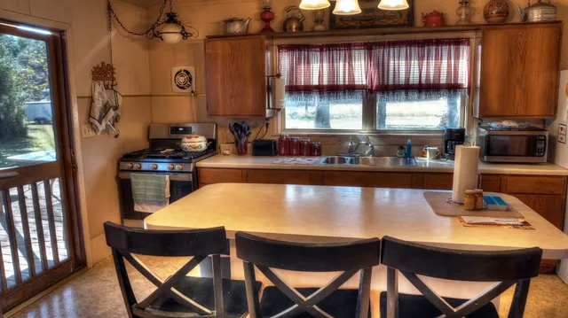 a kitchen with a table chairs and a window