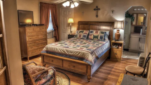 a bedroom with a bed a mirror on dresser and a chandelier